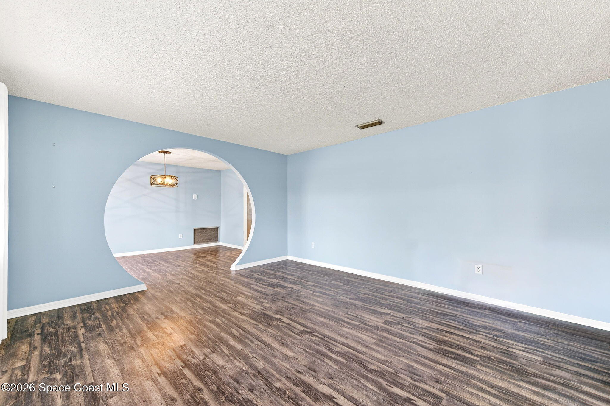 990 Boxford Lane Rockledge, FL 32955 - Photo 10 of 41 a view of a big room with wooden floor and windows