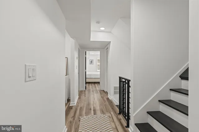 a view of a hallway with wooden floor and entryway