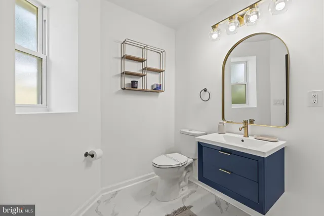 a bathroom with a toilet sink and mirror