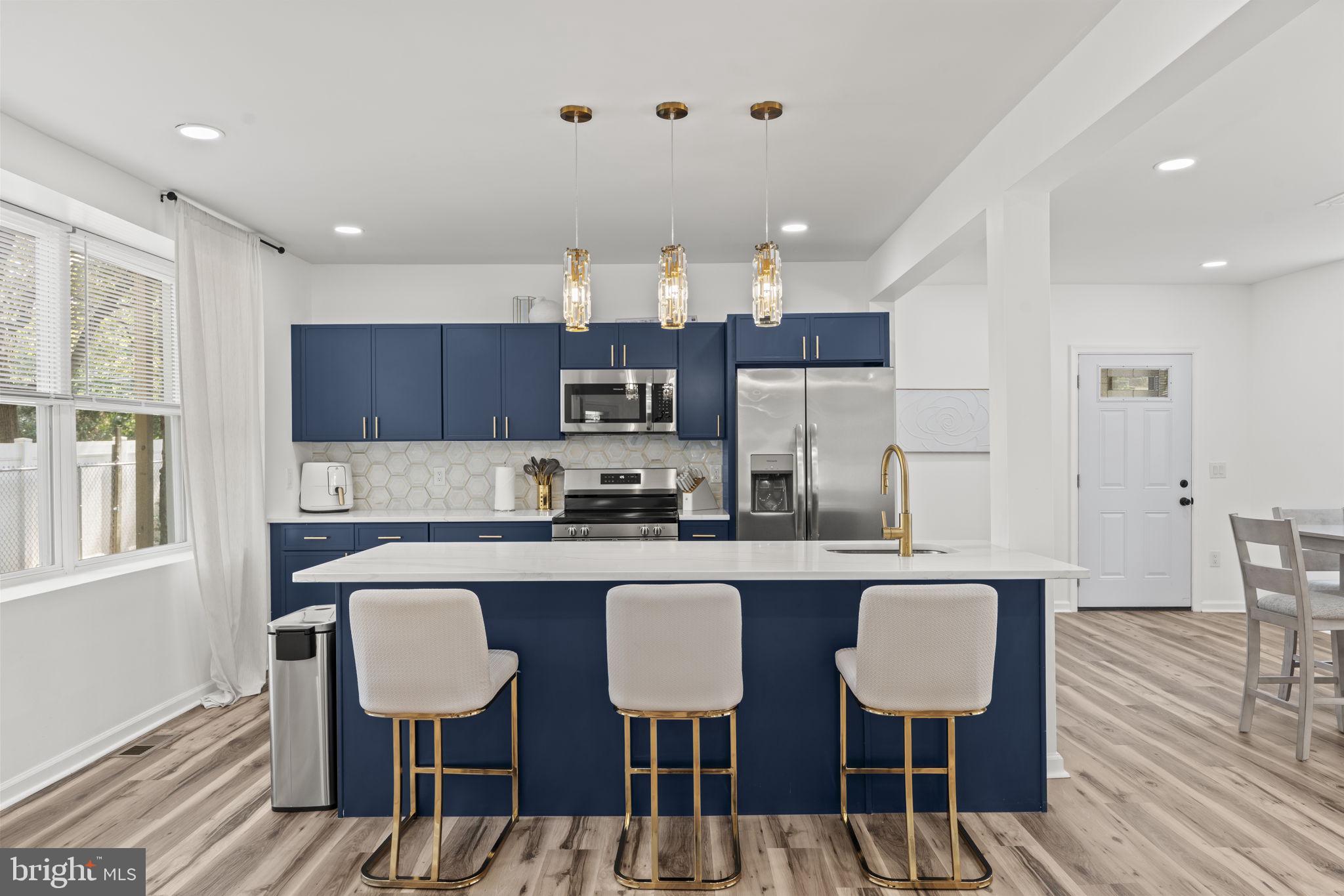 5320 Wynnefield Avenue Philadelphia, PA 19131 - Photo 9 of 33 a kitchen with kitchen island granite countertop a dining table chairs refrigerator and sink
