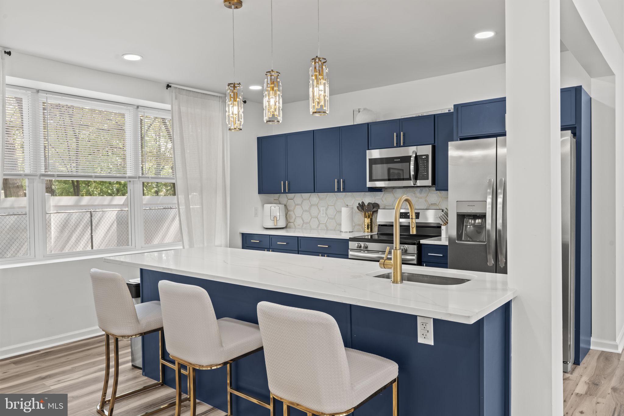 5320 Wynnefield Avenue Philadelphia, PA 19131 - Photo 10 of 33 a kitchen with stainless steel appliances granite countertop a dining table chairs refrigerator and sink