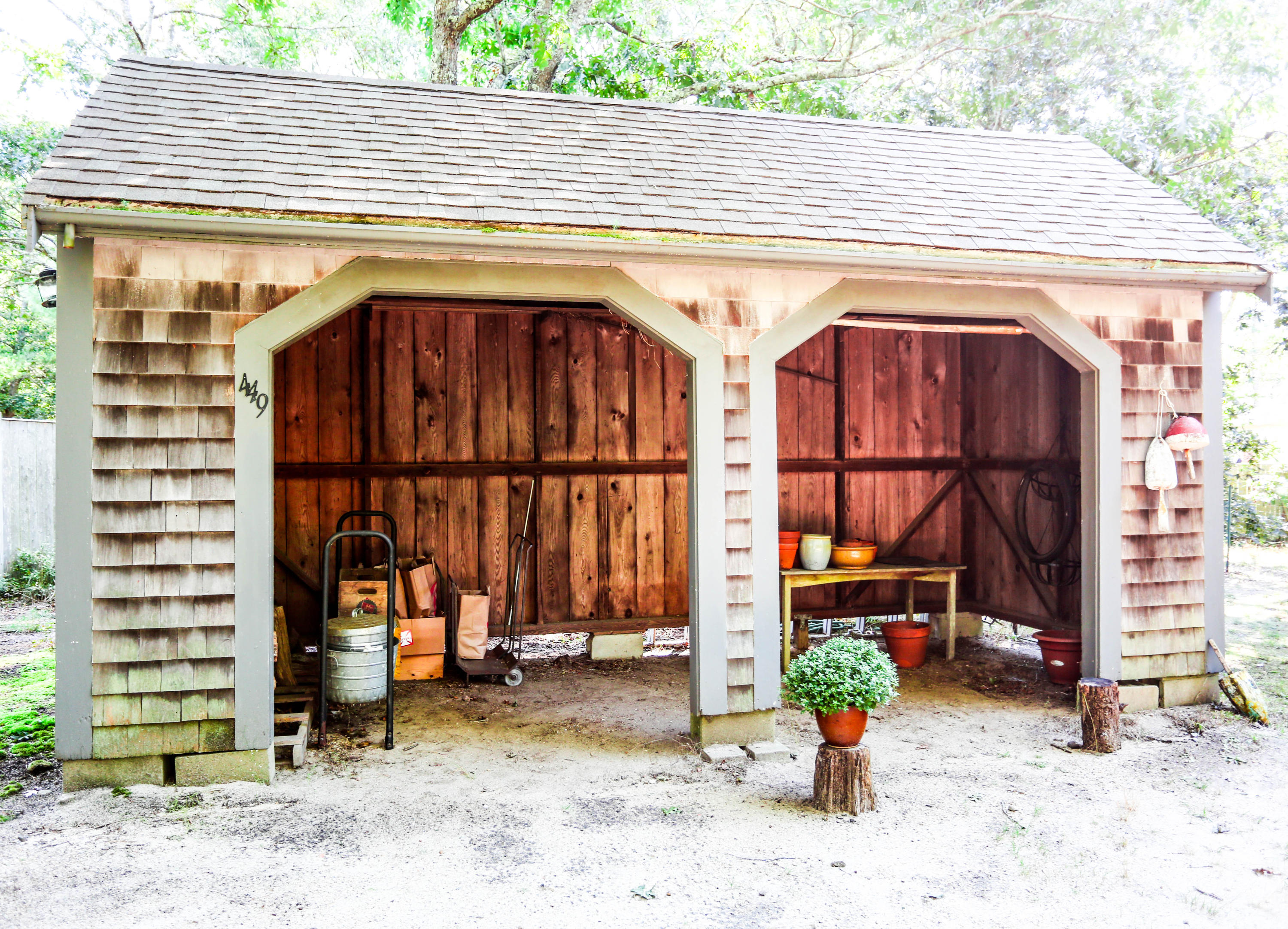 449 Poponessett Road Cotuit, MA 02635 - Photo 12 of 17 a view of a wooden house with a potted plant