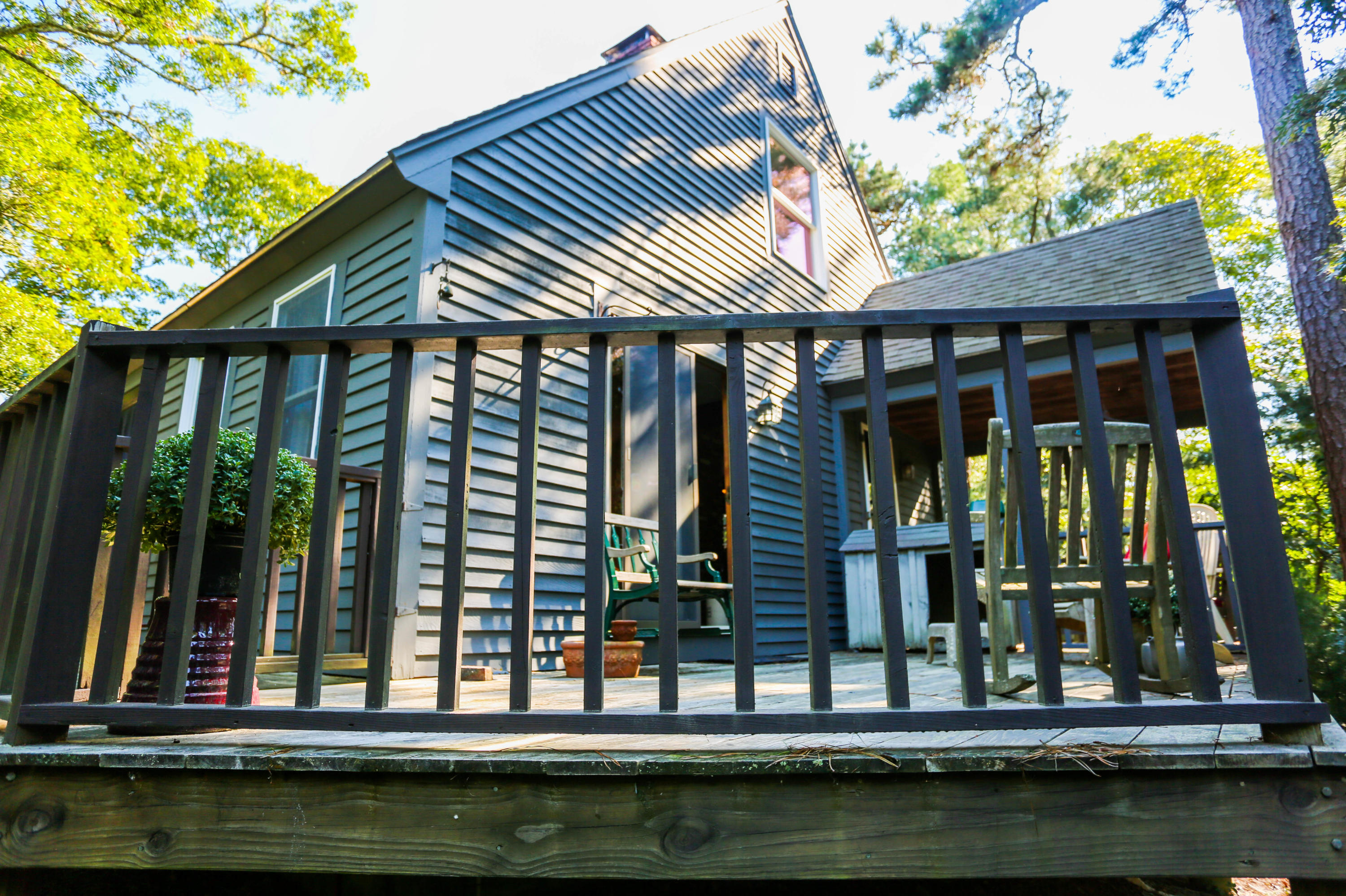 449 Poponessett Road Cotuit, MA 02635 - Photo 2 of 17 a front view of a house with swimming pool and glass windows
