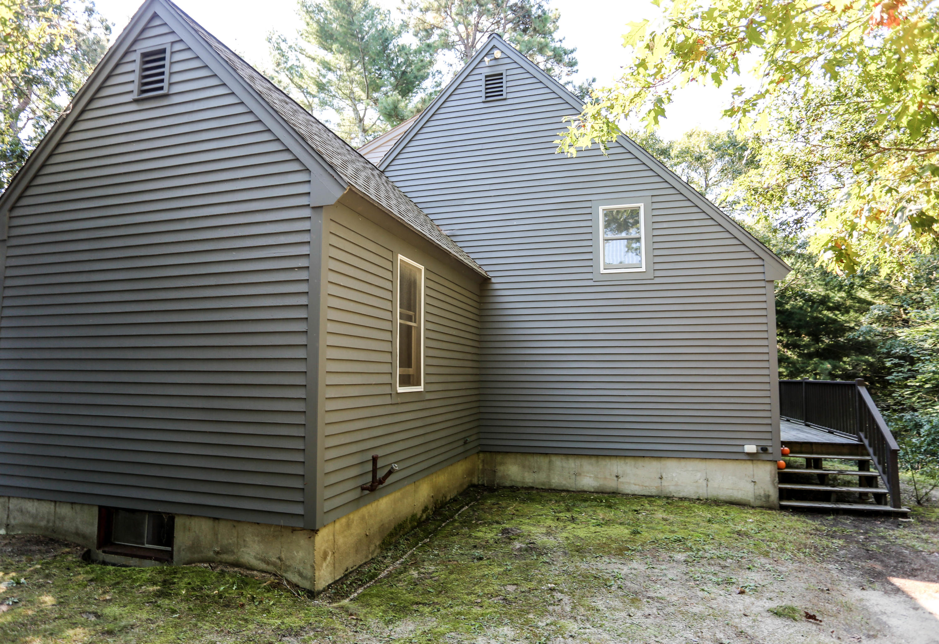 449 Poponessett Road Cotuit, MA 02635 - Photo 4 of 17 a view of a small house with a yard and garage