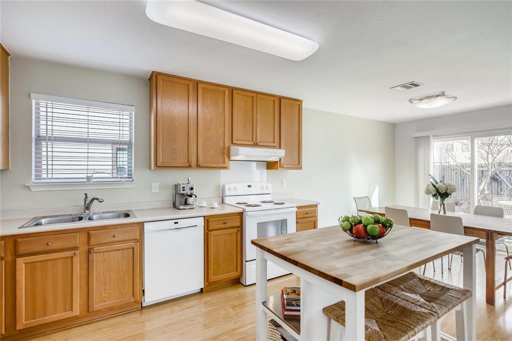 8813 Winter Haven Road Austin, TX 78747 - Photo 14 of 28 a kitchen with a sink cabinets and wooden floor