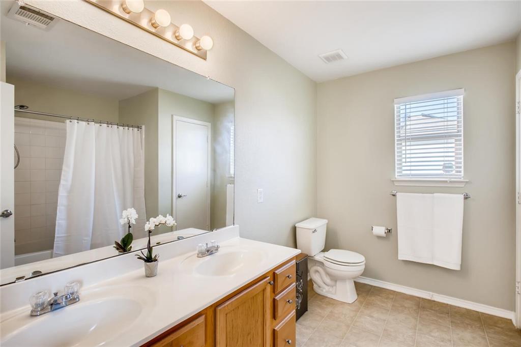 8813 Winter Haven Road Austin, TX 78747 - Photo 19 of 28 a bathroom with a sink a toilet and mirror