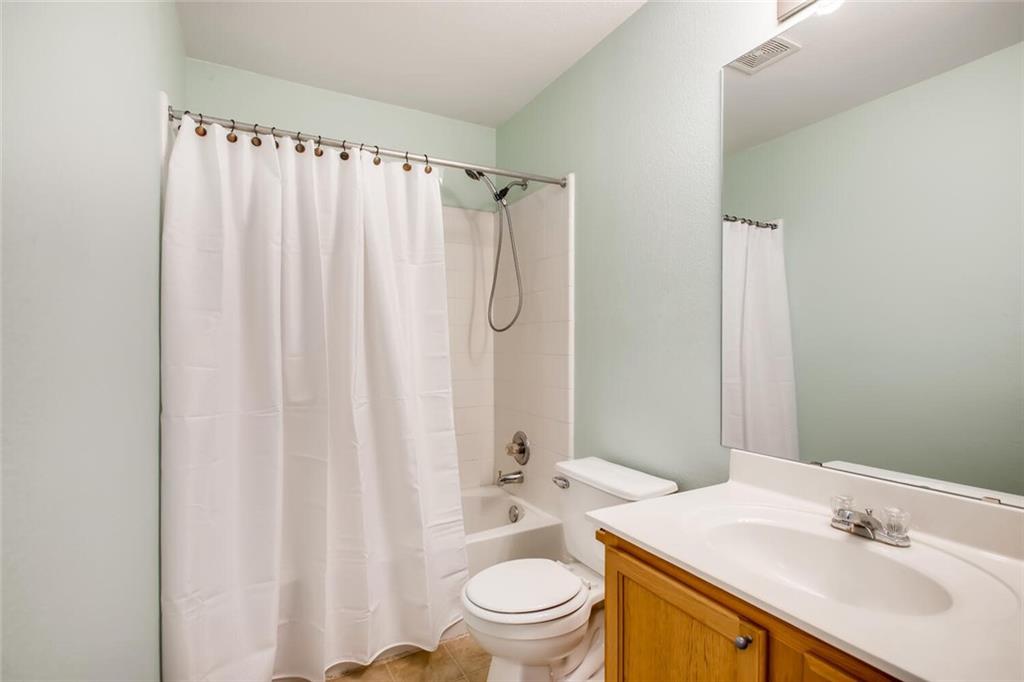 8813 Winter Haven Road Austin, TX 78747 - Photo 22 of 28 a bathroom with a sink a toilet and shower curtain