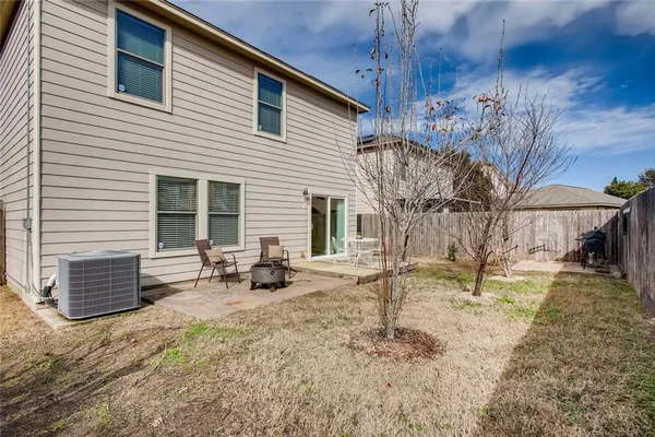 a backyard of a house with barbeque oven table and chairs