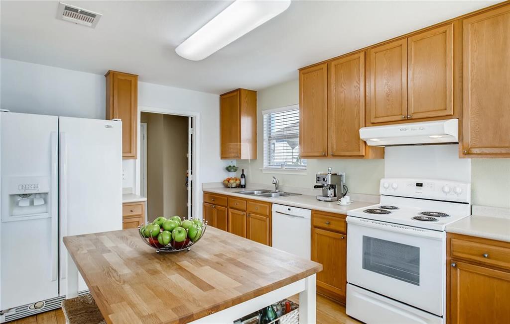 8813 Winter Haven Road Austin, TX 78747 - Photo 3 of 28 a kitchen with a stove a refrigerator and a cabinets