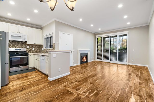a dining room with wooden floor a chandelier a wooden table and chairs