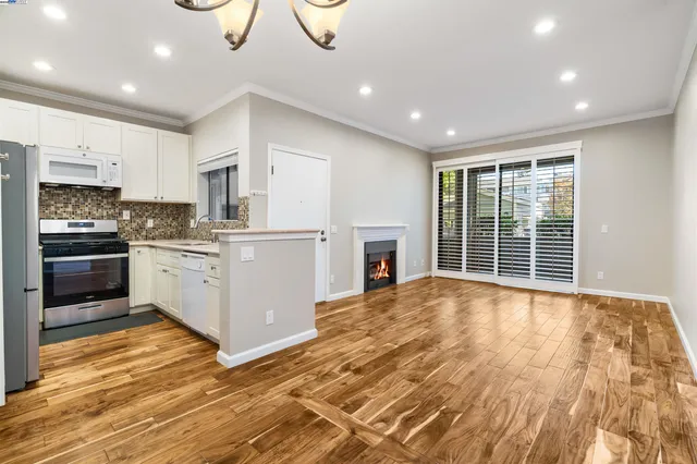 a dining room with wooden floor a chandelier a wooden table and chairs