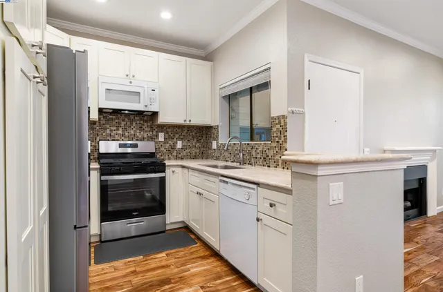 a kitchen with granite countertop a refrigerator stove and sink