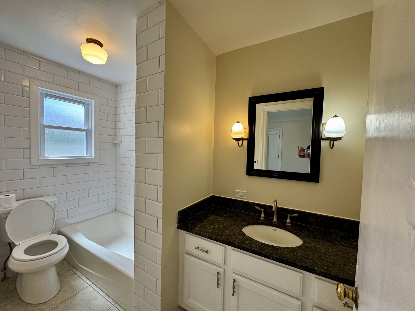 844 Deerfield Road, Unit 2 Highland Park, IL 60035 - Photo 11 of 18 a bathroom with a granite countertop sink a toilet and a mirror