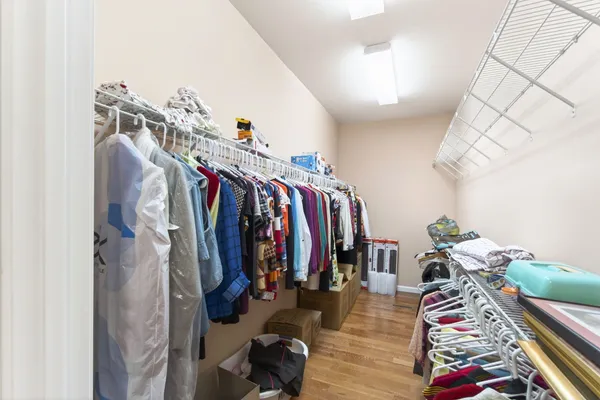 a view of walk in closet with clothes and shoes