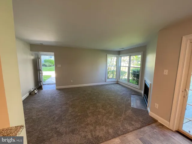 a view of an empty room with wooden floor and closet