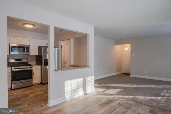 a view of an empty room with a fireplace and a window