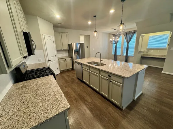 a kitchen with sink stove and refrigerator
