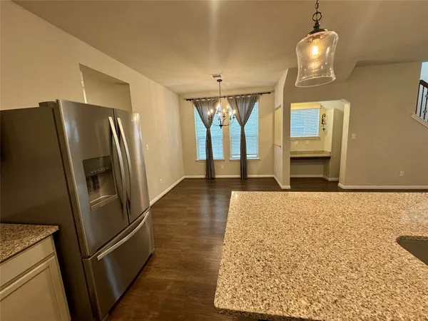 a view of a refrigerator in kitchen and wooden floor