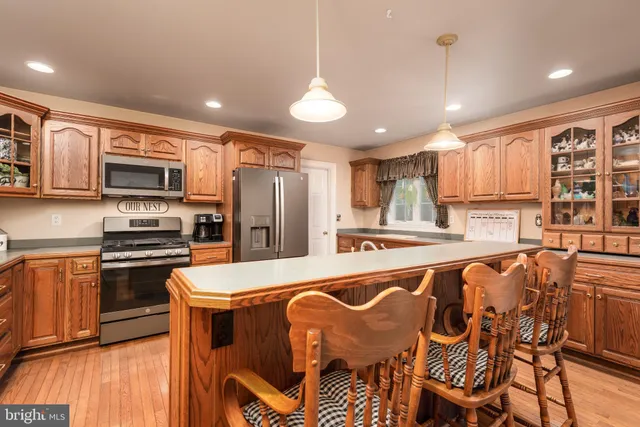 a kitchen with stainless steel appliances granite countertop a sink a stove and a wooden floors