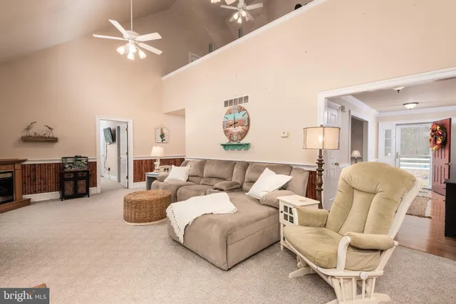 a living room with furniture a flat screen tv and kitchen view