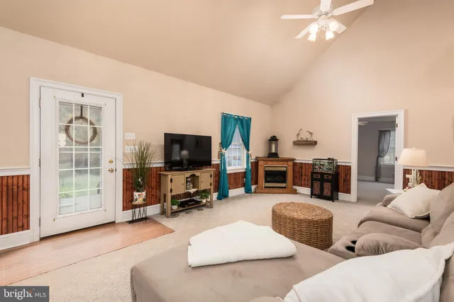 a dining room with wooden floor a chandelier a wooden table and chairs