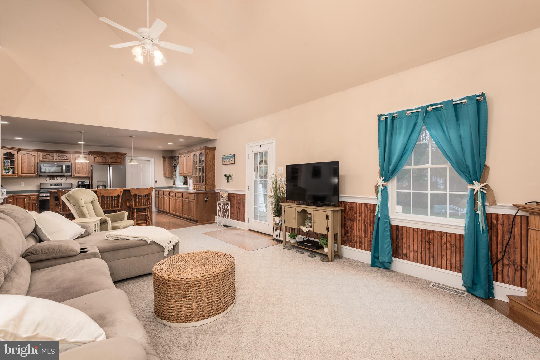 1002 Burrisville Road Centreville, MD 21617 - Photo 25 of 50 a living room with furniture a flat screen tv and kitchen view