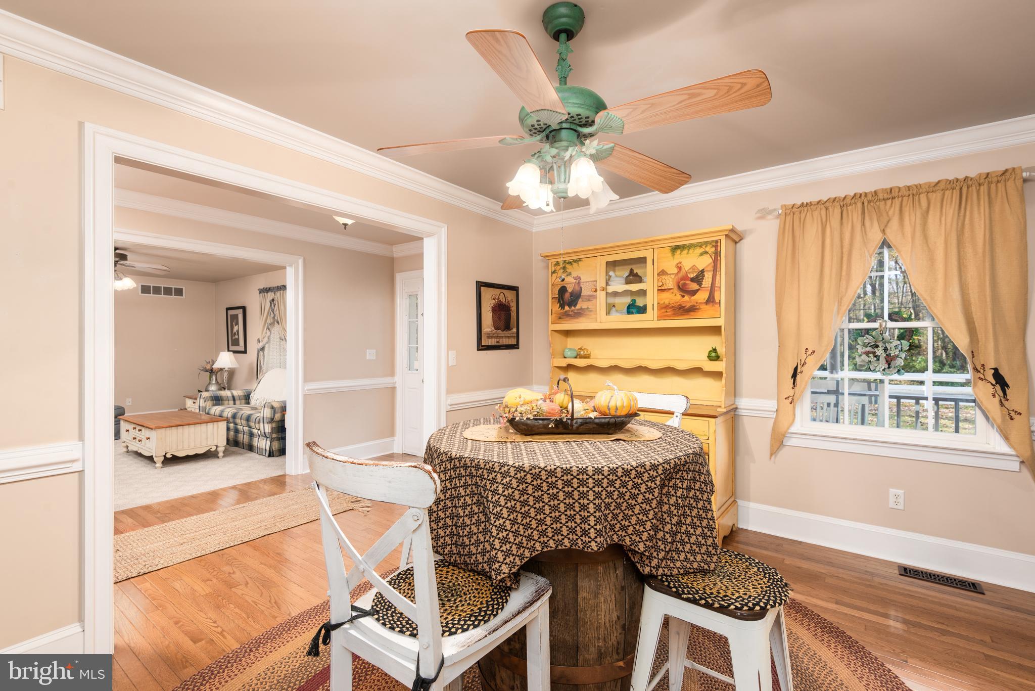 1002 Burrisville Road Centreville, MD 21617 - Photo 26 of 50 a dining room with wooden floor a chandelier a wooden table and chairs