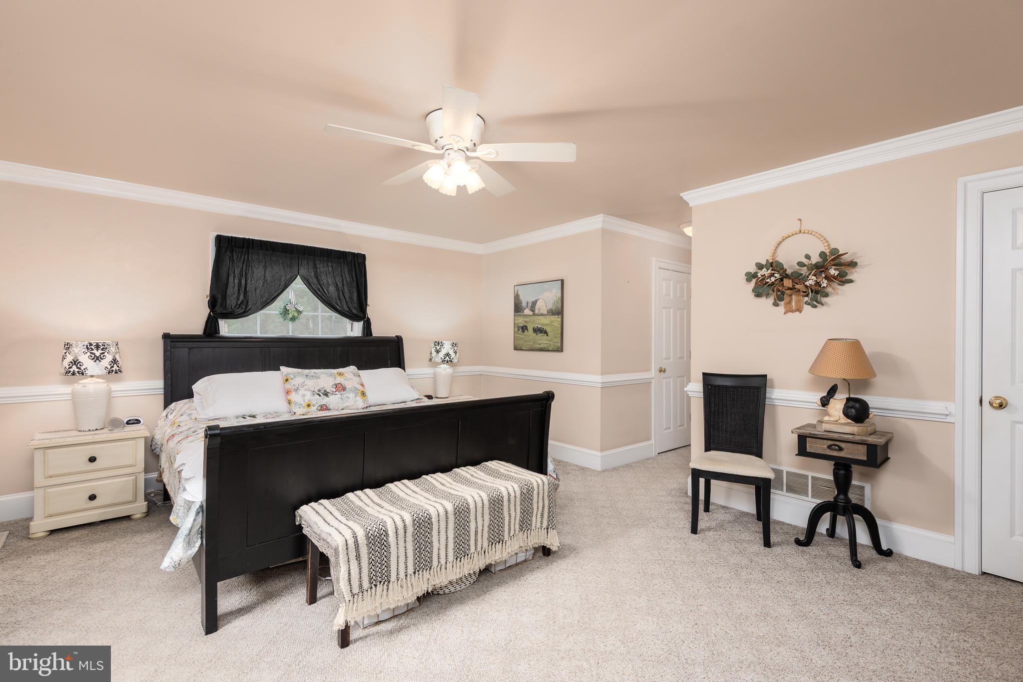 1002 Burrisville Road Centreville, MD 21617 - Photo 28 of 50 a bedroom with a bed and a chandelier