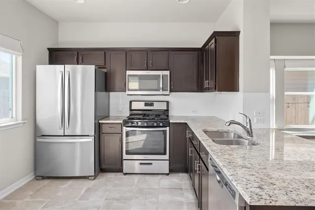 a kitchen with granite countertop a refrigerator and a sink