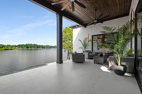a view of a patio with couches potted plants and a floor to ceiling window