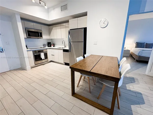 a kitchen with a refrigerator a stove top oven a sink dishwasher and a refrigerator
