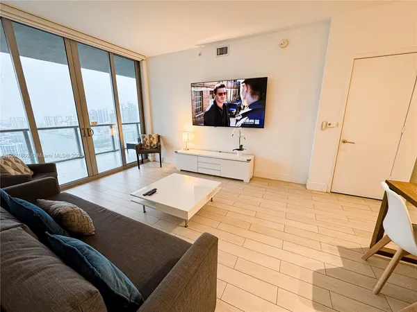 a living room with a couch a rug and a large window