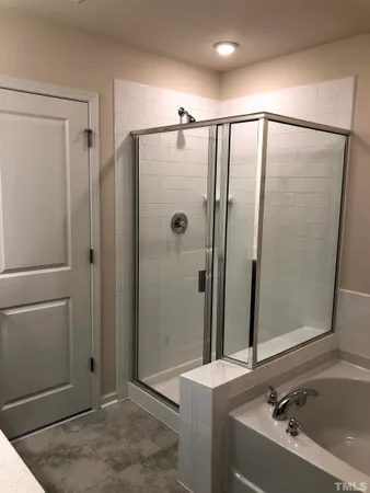 a bathroom with a tub a sink and a mirror