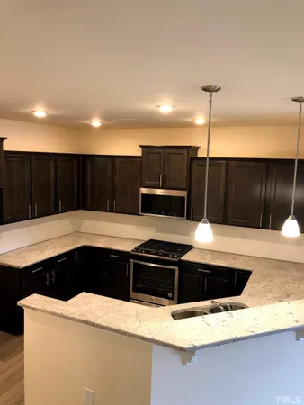 a kitchen with stainless steel appliances kitchen island a white stove sink and cabinets