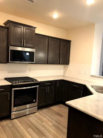 a kitchen with stainless steel appliances a stove a microwave and sink