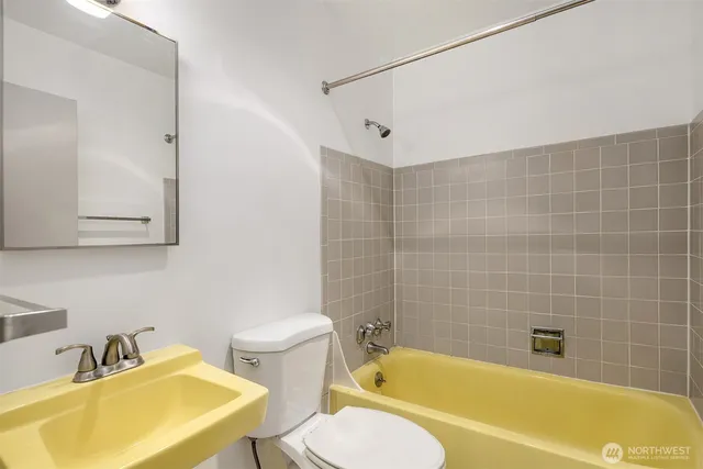 a bathroom with a sink mirror bathtub and toilet