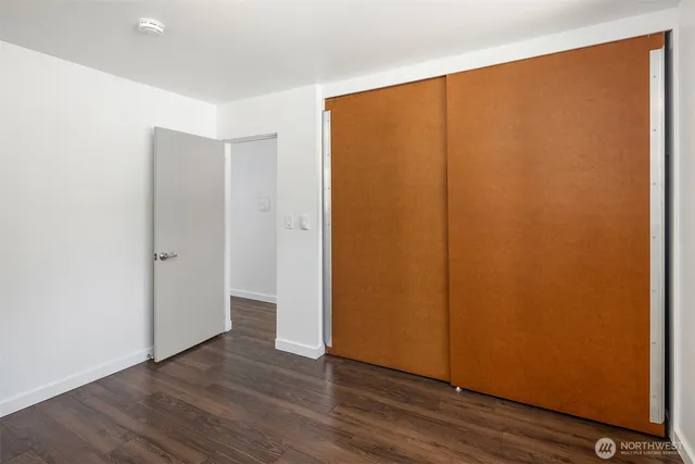 an empty room with wooden floor and closet