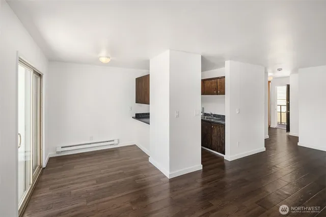 a view of a kitchen with wooden floor and a refrigerator