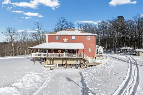 a view of a house with snow on the side of the road