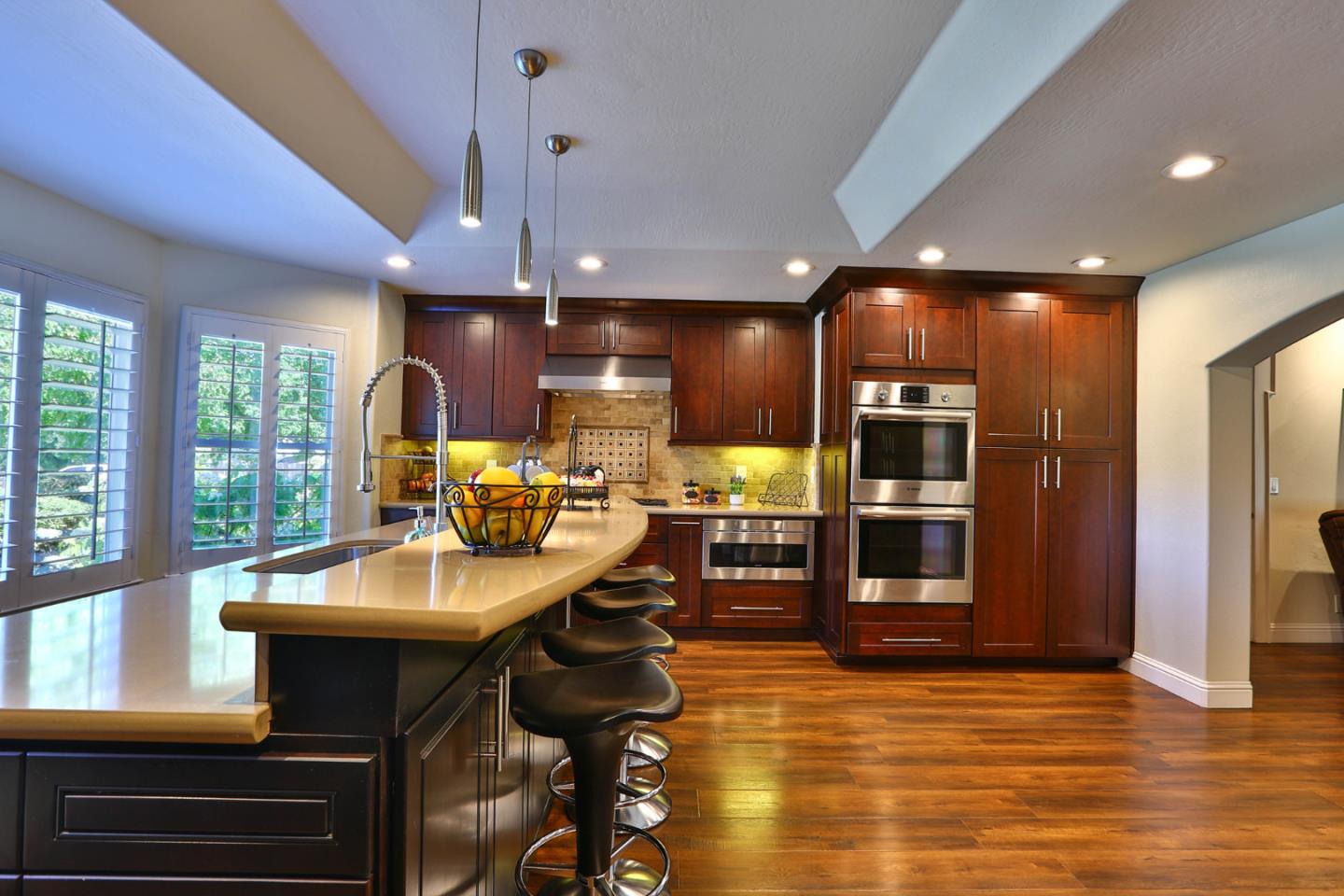 2000 Day Road Gilroy, CA 95020 - Photo 8 of 51 a kitchen with stainless steel appliances kitchen island granite countertop a refrigerator a stove a dining table and chairs with wooden floor