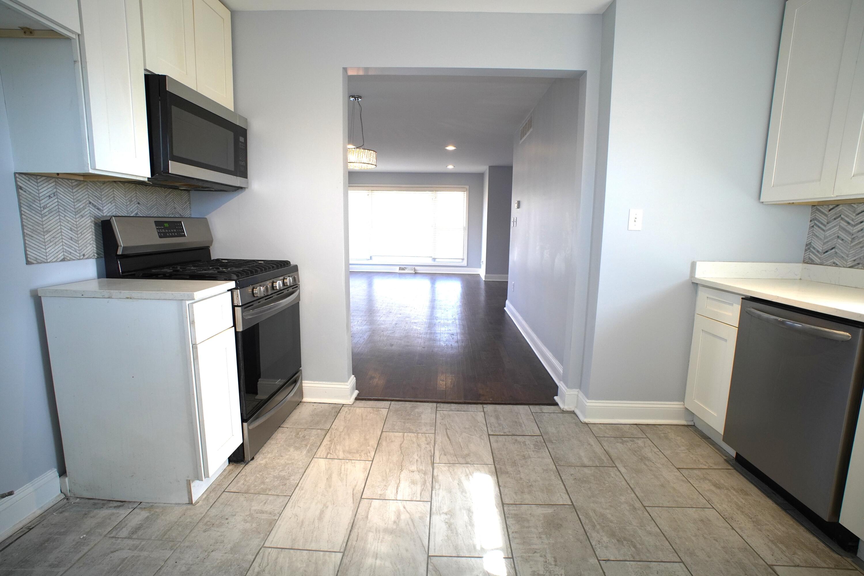 1312 Bigger Street Gary, IN 46404 - Photo 24 of 33 a kitchen with a stove top oven a sink a counter space and cabinets