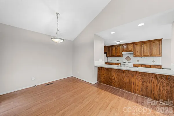 a view of a kitchen with wooden floor and a ceiling fan