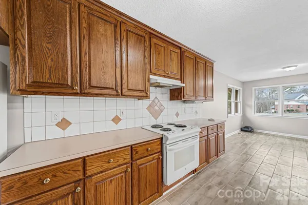 a kitchen with stainless steel appliances granite countertop a stove a sink dishwasher and cabinets with wooden cabinets