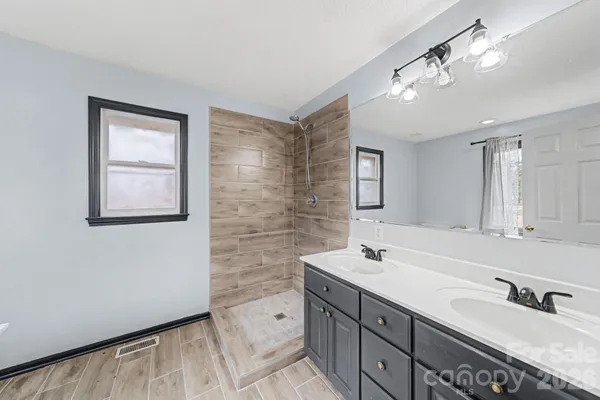 a bathroom with a sink a mirror and a shower