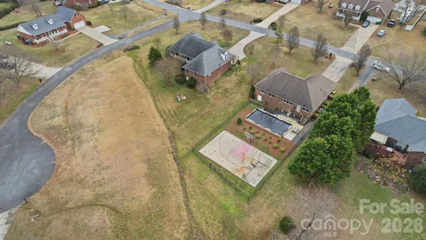 an aerial view of a house with a yard basket ball court and outdoor seating