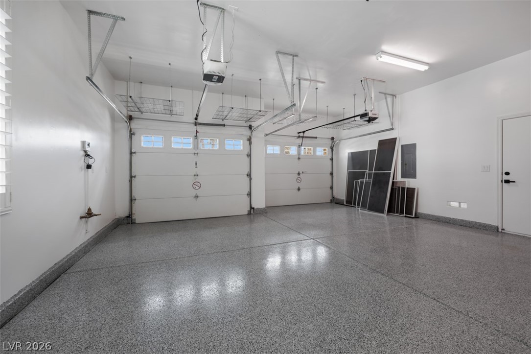 5015 Rivedro Street Las Vegas, NV 89135 - Photo 52 of 91 A spacious, well-lit garage features two overhead doors and a durable, easy-to-maintain epoxy floor.