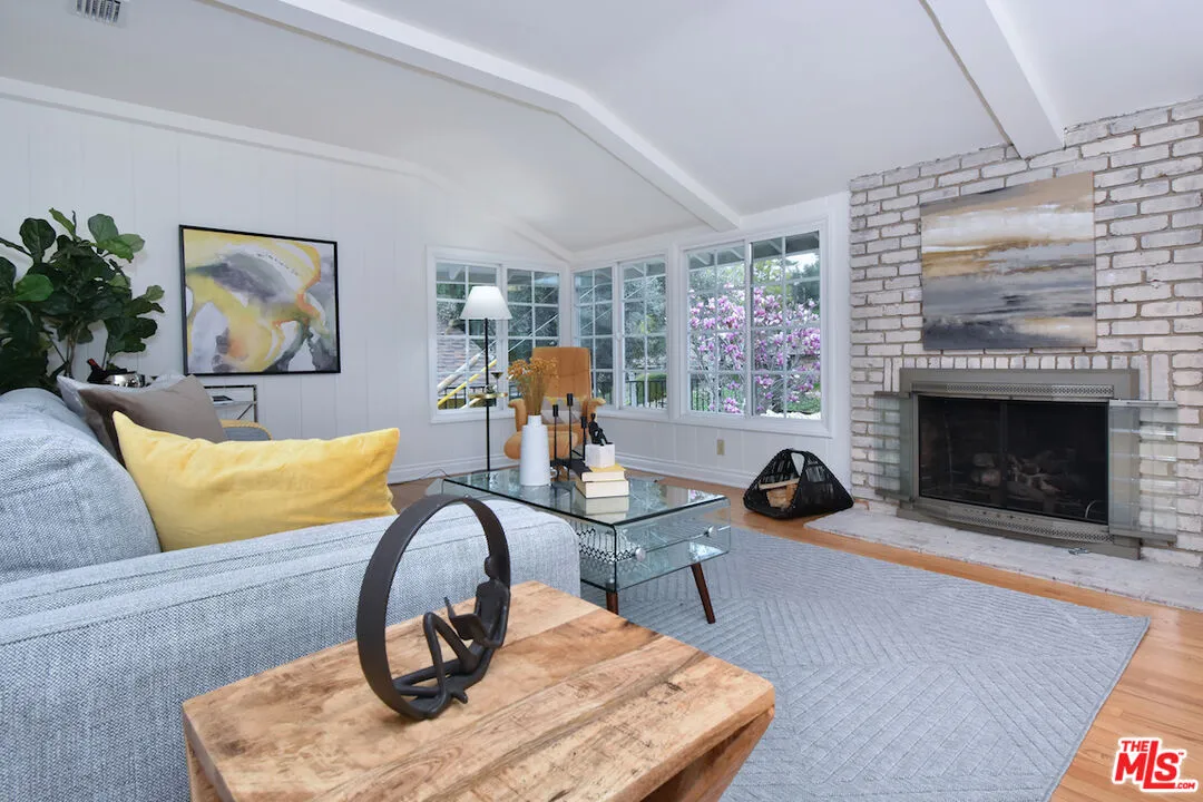 a living room with furniture a fireplace and potted plants