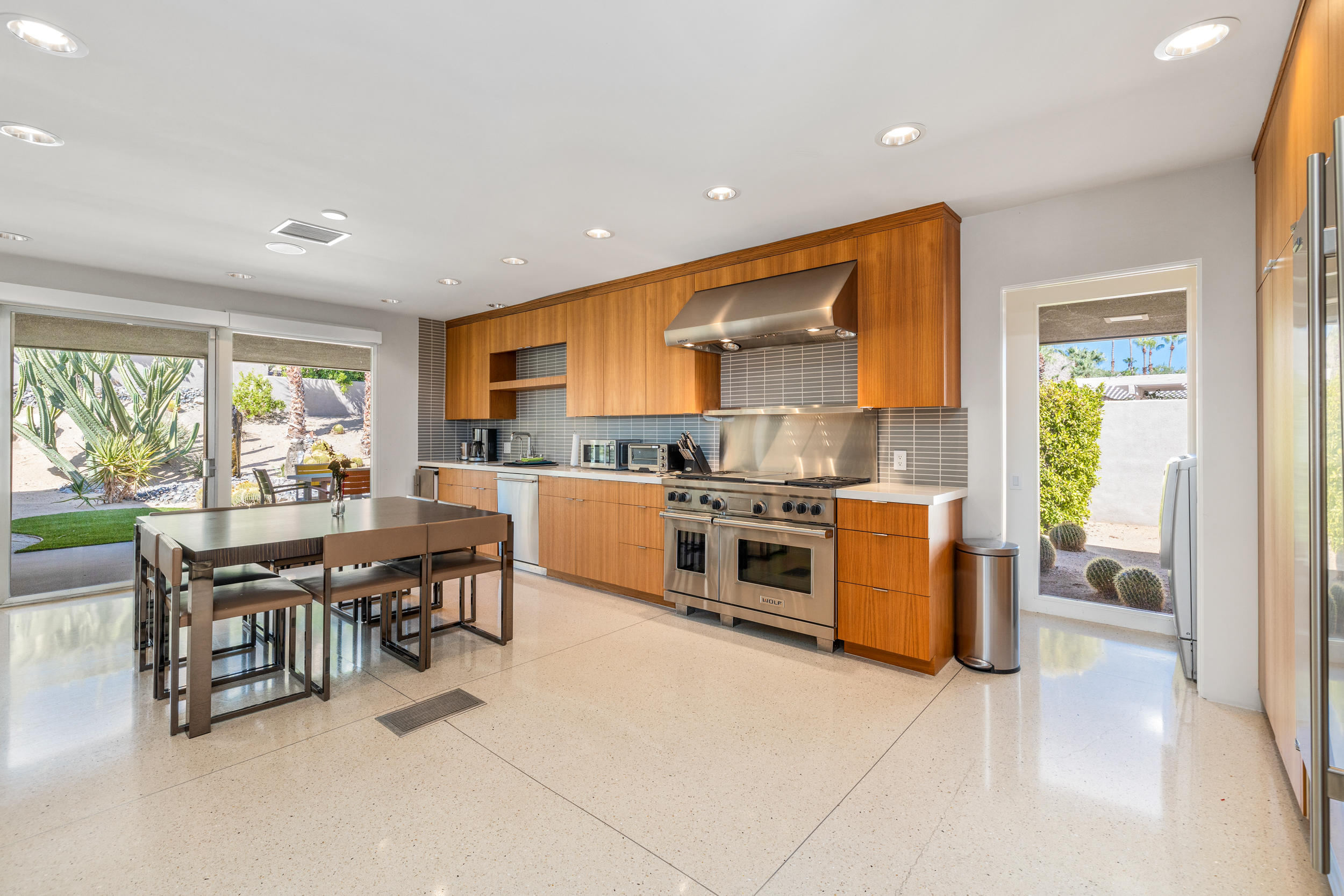 70411 Pecos Road Rancho Mirage, CA 92270 - Photo 9 of 44 a kitchen with stainless steel appliances kitchen island granite countertop a stove a sink a dining table and chairs