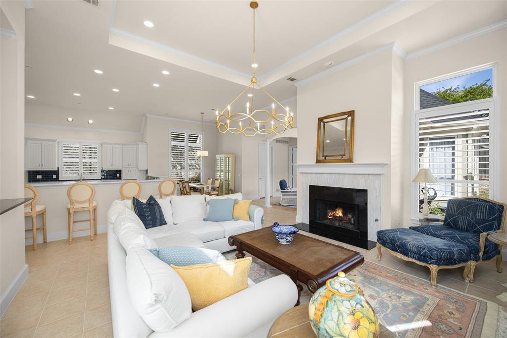 a living room with furniture a chandelier and a fireplace