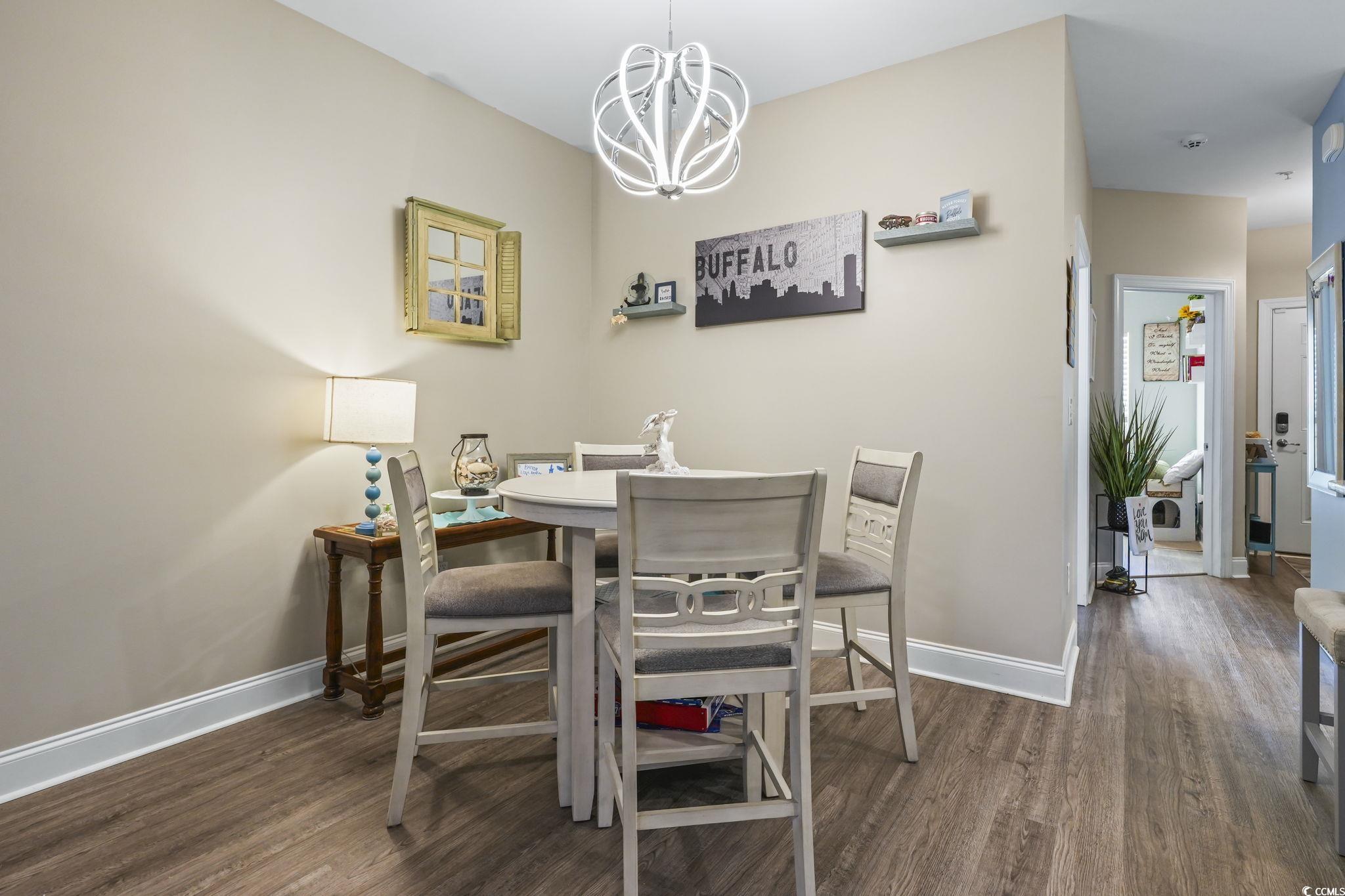 124 Birch N Coppice Drive, Unit 3 Surfside Beach, SC 29575 - Photo 10 of 40 Dining area with a chandelier and dark wood-style floors